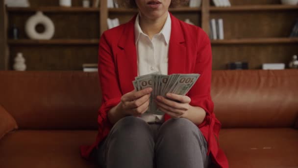 一个穿着时髦红色西装的女人的特写镜头 她数着一叠100美元的钞票 金融的概念和成功 — 图库视频影像