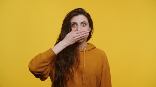 Young Woman Mustard Hoodie Covers Her Mouth Hand Looking Surprised — Vídeo de stock