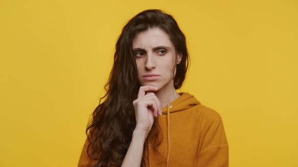 Young Woman Contemplative Expression Resting Chin Hand Vivid Yellow Backdrop — Vídeo de stock