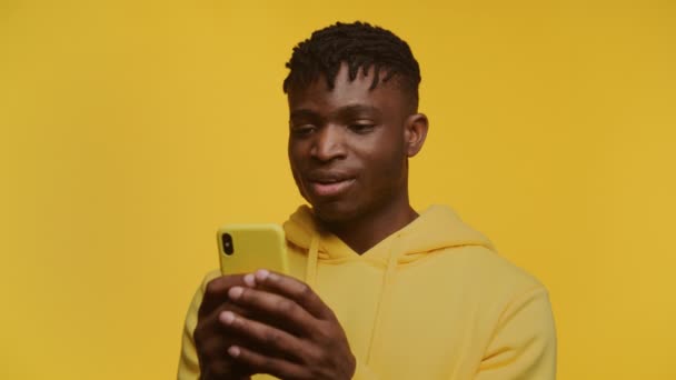 Ein Überschwänglicher Junger Schwarzer Mann Einem Gelben Kapuzenpullover Der Freudig — Stockvideo