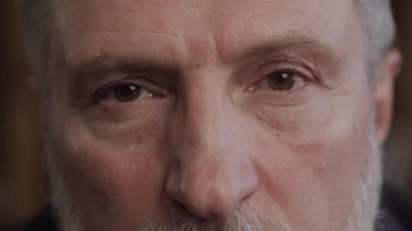 Close-up of a senior mans face with an intense gaze, focusing on his eyes and facial features