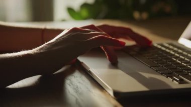 Dizüstü bilgisayarın dokunmatik dokunmatik bir dokunmatik ekranında el yapımı dramatik bir yakın plan, sıcak, altın bir güneş ışığı ile vurgulanarak, sakin bir çalışma alanı ortamı yaratıyor.
