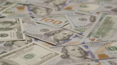 Dağınık yüz dolarlık banknotların yakın çekim görüntüsü, sergilenen finansal bolluk