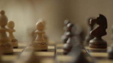 Satranç tahtasındaki ahşap satranç taşlarının yakın plan çekimleri strateji ve konsantrasyonu vurguluyor.