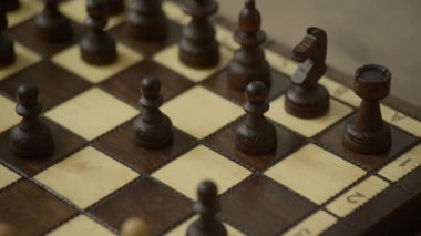Klasik bir satranç tahtasında, strateji ve entellektüel oyun üzerine odaklanmış ahşap satranç taşlarının yakın çekimi
