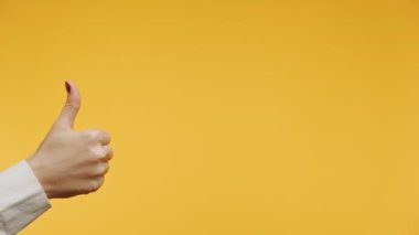 Parlak sarı bir arkaplan karşısında el hareketi yapmak.