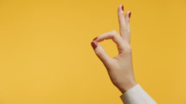 El, parlak sarı bir arka plana karşı iyi bir hareket yapıyor.