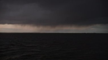 Nehrin üzerindeki kara bulutlar ufukta bir ışık belirmesi yaklaşan bir fırtınayı işaret ediyor.