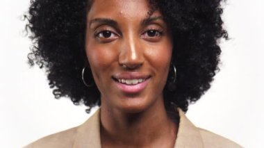 Beyaz arka planda kıvırcık saçlı ve halka küpeli gülümseyen bir kadının yakın plan portresi.