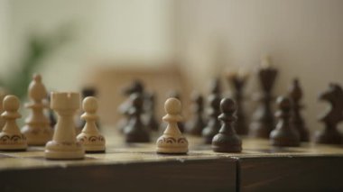 Ahşap bir satranç tahtasına yakın plan ve bulanık bir arkaplan.