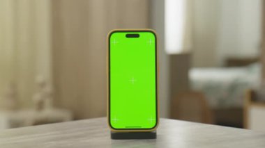 Yeşil ekranlı Dolly zoom akıllı telefon modern kapalı bir ortamda bir masanın üzerine yerleştirilir, krom anahtarlama için mükemmeldir