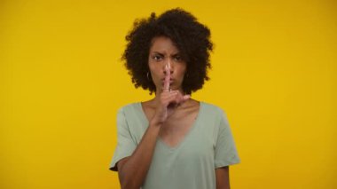 Kıvırcık saçlı genç bir kadının portresi. Parmağıyla dudaklarını kapatıyor. Açık yeşil bir bluz giyiyor.