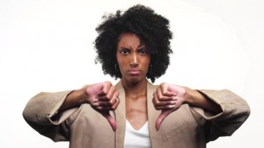 Kıvırcık saçlı mutsuz bir kadın, beyaz tenli, onaylamadığını belirten iki kez baş parmak hareketi yapıyor.