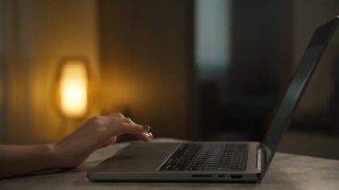 Laptop Touchpad 'de kadın el taraması. Yakın çekim, arka planda sıcak akşam aydınlatması.