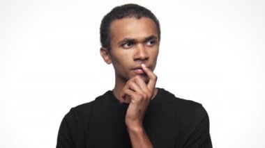 Düşünceli bir yüz ifadesi olan bir adam, eli çenesinde, yukarı bakıyor sanki beyaz bir arka plana karşı bir şeyler düşünüyor gibi.