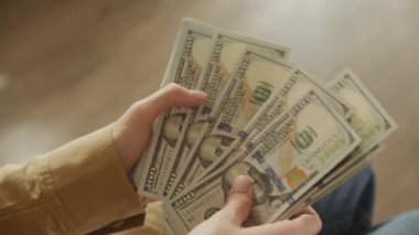 Zenginlik, finans ve para işleme odaklı, birden fazla Amerikan doları banknotunu tutan ve sayan kişilerin yakın çekimleri