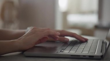 Uzaktan çalışma veya ev ofis temalarını görüntülemek için mükemmel olan bulanık arkaplanı olan bir dizüstü bilgisayarda yazı yazan ellerin yakın plan görüntüsü