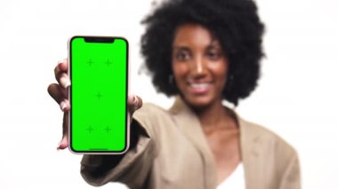 Elinde yeşil ekranlı akıllı telefon tutan bir kadın. Model amaçlı. Telefona odaklı.
