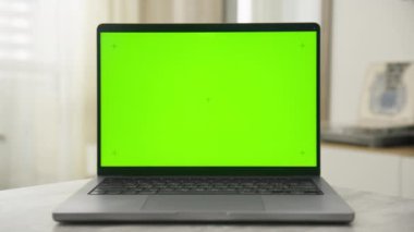 Masa başı yakınlaştırmasında krom anahtar işaretleri olan yeşil ekranı gösteren bir dizüstü bilgisayar, görüntü veya resim birleştirmeye hazır