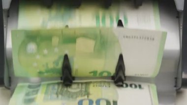 Hareket halindeki 100 Euro 'luk banknotları sayan bir para sayma makinesine yakın çekim.