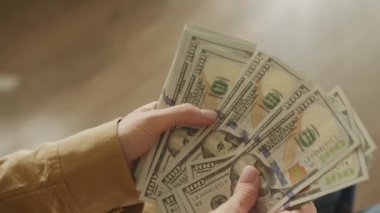 Çok sayıda 100 dolarlık banknotları tutan el kameraları.