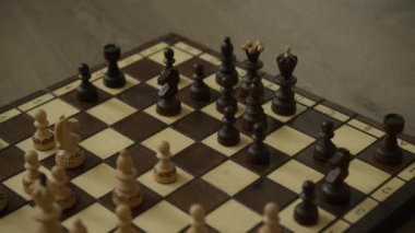 Klasik bir satranç tahtasına dizilmiş tahta satranç taşları stratejik bir oyuna hazır.