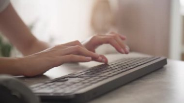 Ev ofis ortamında kablosuz bir klavyede yazı yazan ellerin yakın çekimi, çalışmanın verimliliği ve modern teknolojinin sergilenmesi