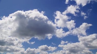 Pofuduk beyaz bulutlu parlak mavi gökyüzü güneşli bir günde doğanın güzelliğini ve sakin bir atmosfer manzarasını yakalıyor.