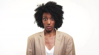 Bej ceketli iş kadını şaşırmış, gözleri tamamen açık, beyaz arka planda..