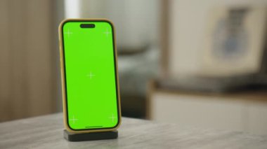 Yükleme rıhtımında yeşil ekranlı akıllı telefon, ev ortamında krom anahtar kullanımına hazır