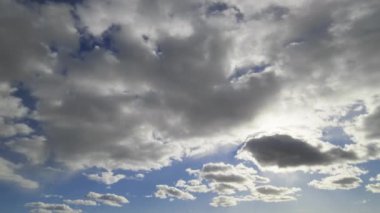 Güneşin parladığı parçalı bulutlu bir gökyüzünün zamansal görüntüsü dinamik bulut hareketlerini ve doğal ışık geçişlerini vurguluyor..