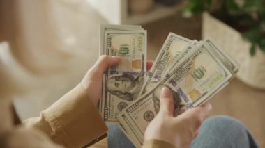 100 dolarlık banknotları sayarak, kişisel finans ve zenginlik yönetiminin altını çizerek, yakın plan çekimleri.
