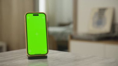 Yörüngesel bir hareketle metin veya grafikler için yeterli kopya alanına sahip yeşil renkli anahtar ekrana sahip bir akıllı telefon.