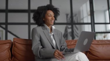 Modern bir ofis ortamında oturan iş kadını profesyonel bir video görüşmesine katılıyor..