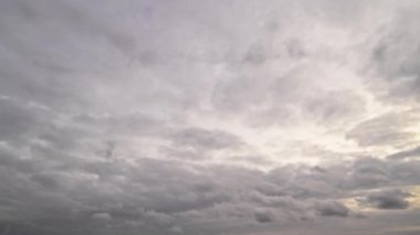 Yoğun gri bulutların yer değiştirdiği dinamik bir sonbahar gökyüzü görüntüsü, dingin bir zaman dilimi etkisi yaratıyor.