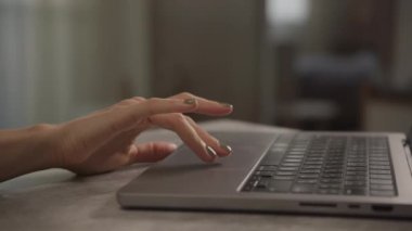 Detaylı yakın plan parmaklar bir dizüstü bilgisayarla hafifçe etkileşime giriyor, hassas ve teknolojik kullanım gösteriyor..