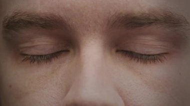 Yavaş çekimde, dramatik bir etki yaratmak için doğrudan kameraya bakan insan gözlerinin detaylı bir yakın çekimi..