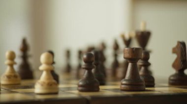 Satranç tahtasındaki ahşap satranç taşlarının detaylı çekimleri stratejik düzenlerine odaklanıyor..