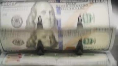 ABD dolarlarının yakın plan görüntüsü bulanık. Para sayma makinesinden hızla işlenmiş. Hareketi ve verimliliği gösteriyor..
