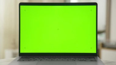 Yeşil ekranlı bir laptopa yavaşça yaklaşan bir kameranın sinematik görüntüsü ekrana doğru pürüzsüz bir şekilde uçuyor..