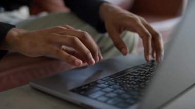 Modern bir ortamda üretkenlik ve teknolojiye odaklanan bir dizüstü bilgisayarın klavyesinde yazı yazan ellerin yakın görüntüsü.