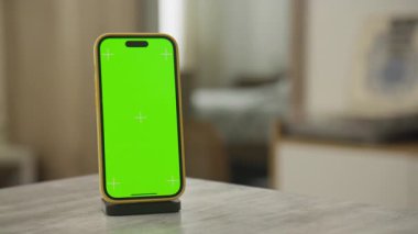 Yeşil ekranlı modern bir akıllı telefonun sinematik yörünge görüntüsü, özelleştirilebilir içerik ve profesyonel video düzenleme için dinamik hareketi yakalıyor.