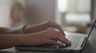 Parlak ve modern bir çalışma alanındaki laptop klavyesinde aktif olarak yazı yazan bir kişinin yakın çekimi, üretkenliği ve odaklanmayı gösterir.