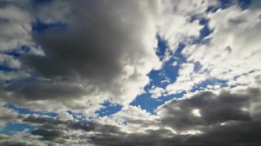 Gökyüzünde kayan dramatik bulutların zaman çizelgesi mavi lekeleri ortaya çıkarıyor ve büyüleyici ve sürekli değişen bir atmosfer sahnesi yaratıyor..