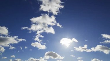 Berrak mavi bir gökyüzünün güzel bir zamanlaması. Kabarık beyaz bulutlar sürükleniyor. Güneş ışıl ışıl parlıyor ve huzurlu bir atmosfer yaratıyor..