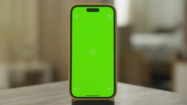 Yeşil ekranlı bir akıllı telefon dramatik bir yakınlaştırma sahnesiyle çekilir ve sinematik bir etki yaratır. Video düzenleme ve kişiselleştirme için ideal.