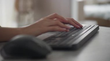 Modern bir ev ofis ortamında kablosuz bir klavyede el yazısının yakın plan çekimi, verimliliği, teknolojiyi ve uzaktan çalışmayı vurguluyor..