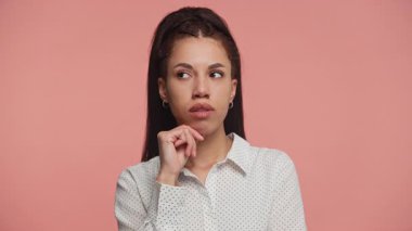 Düşünceli genç bir kadın, elleri çenesinde, derin düşüncelere dalmış, önemli bir kararı düşünürken..