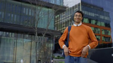 Günümüz cam ofis binalarının yanında güvenle poz veren güler yüzlü bir öğrenci..