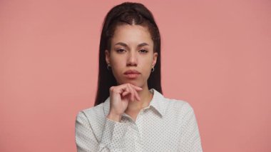 Düşünceli genç bir kadın çenesine dokunup yüzünü çeviriyor, derin düşüncelere dalmış ya da önemli bir karar vermeyi düşünüyor..